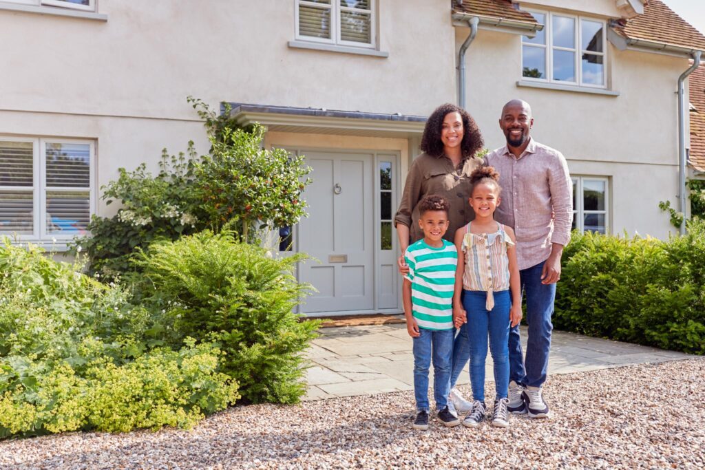 A family in front of their home after renovations.