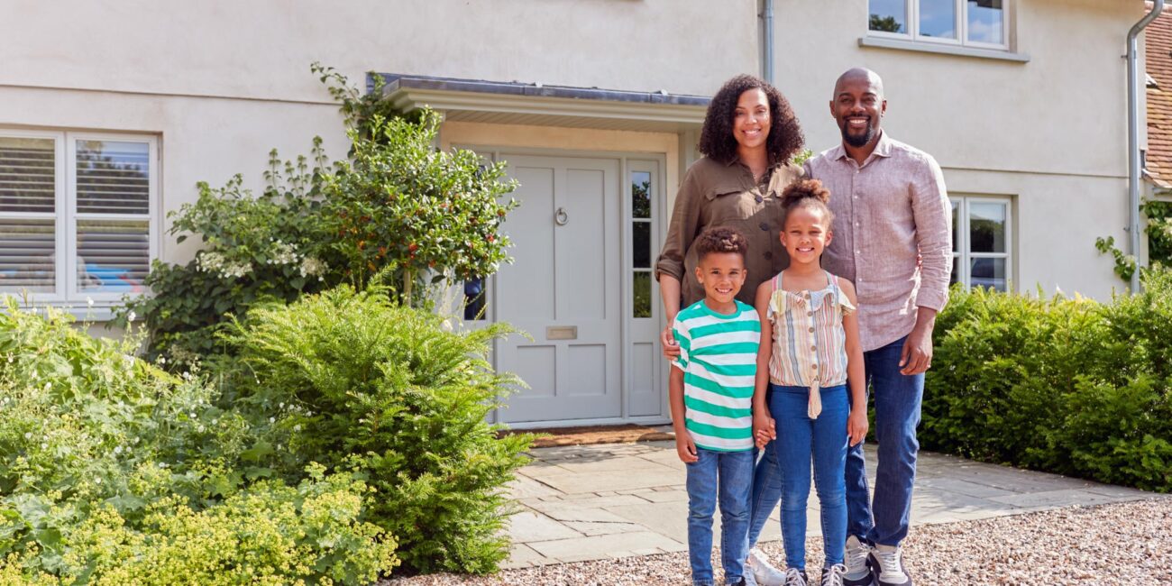 A family in front of their home after renovations.