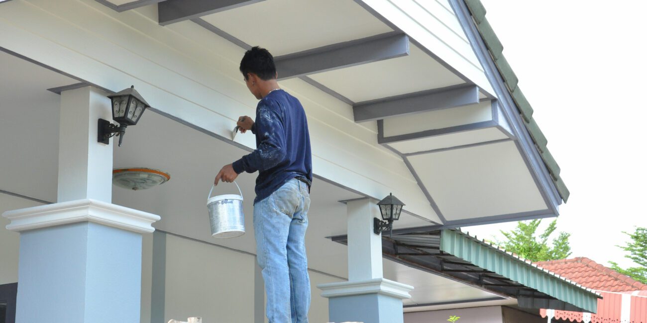 person refreshing a homes exterior